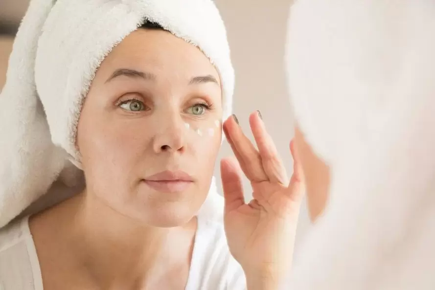 aplicando crema antiengurras baixo os ollos